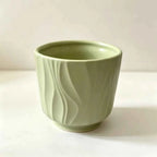Sage green ceramic plant pot with embossed wave pattern