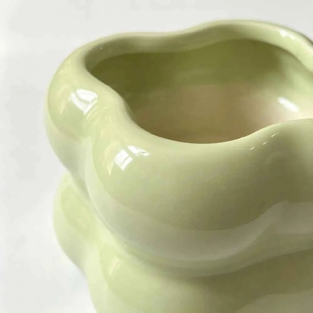 Light green ceramic planter side close-up with glossy finish and rounded opening