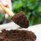 Coconut coir potting soil mound in hand, dark brown, loose fiber texture.