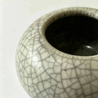 Close-up of cracked white ceramic glaze on low planter rim and opening